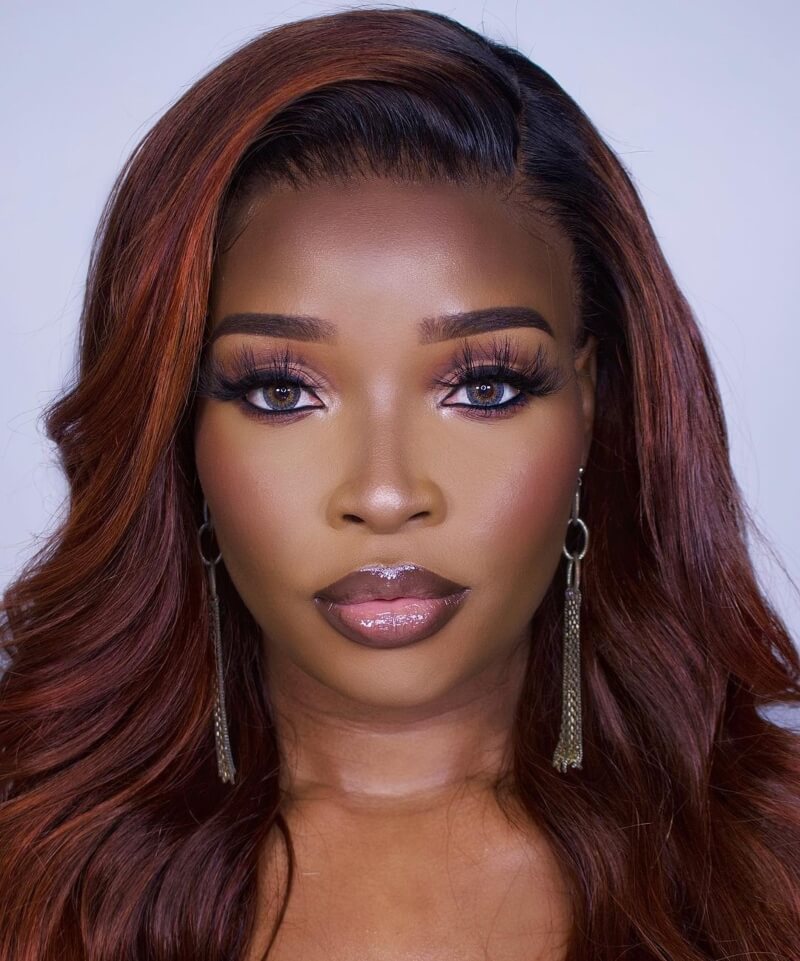 Deep burgundy hair with black roots on dark skin