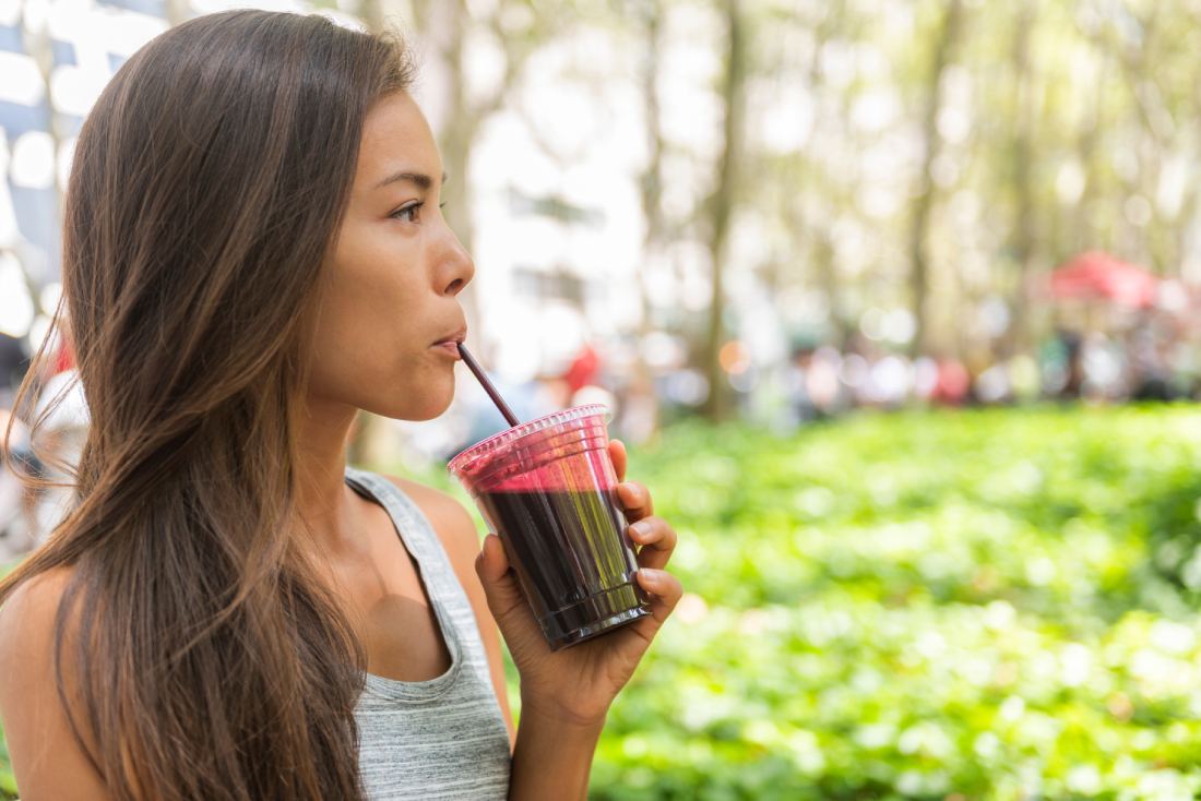 Woman drinking smoothie outside