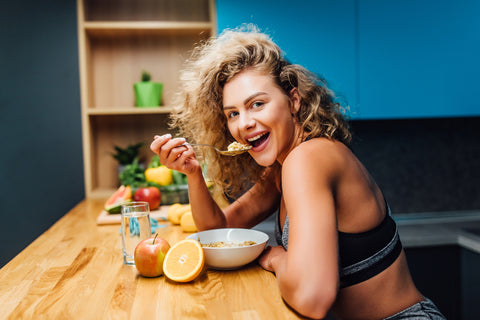 Fitness girl eating a bowl of oatmeal