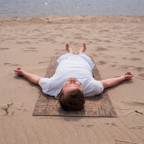 A person lying down and relaxing at the beach