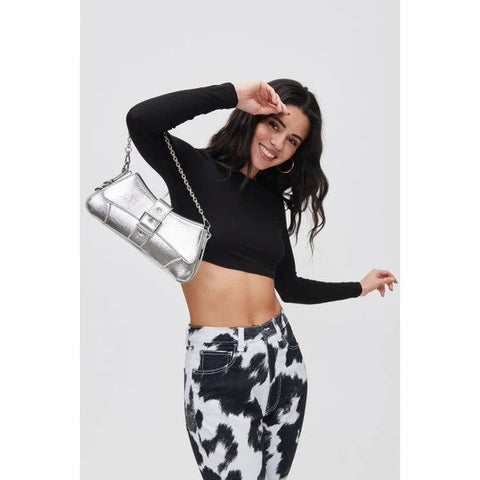 A woman in cow print pants holding a silver 90s baguette bag