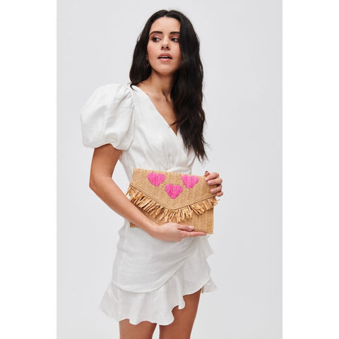 Woman holds Valentine’s straw clutch with pink hearts clutch purse