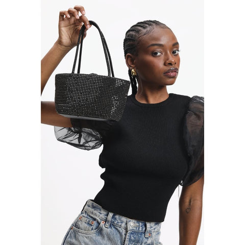 A woman holds a black rhinestone evening purse