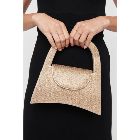 A woman’s hands hold the handle of a gold evening spring bag in a black dress