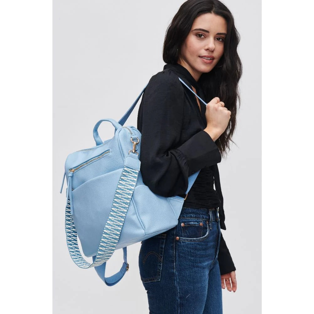 girl carrying light blue vacation backpack