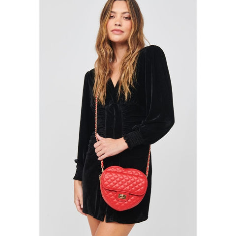 Woman in black dress holds red Valentine’s heart purse