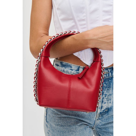 Woman holds a red Valentine’s purse with chain detail