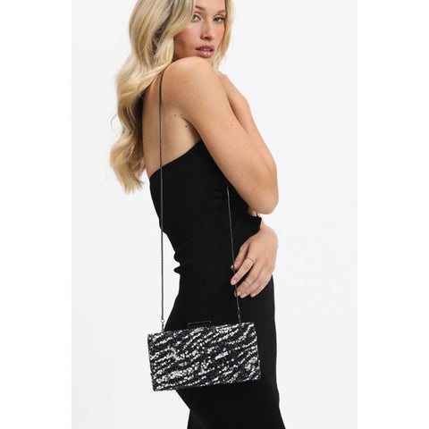 Woman with sequined silver and black evening purse