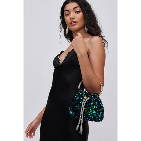 a woman in a black dress with a green sparkly winter handbag