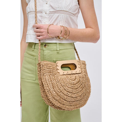 A woman holds a straw Mother’s Day purse.