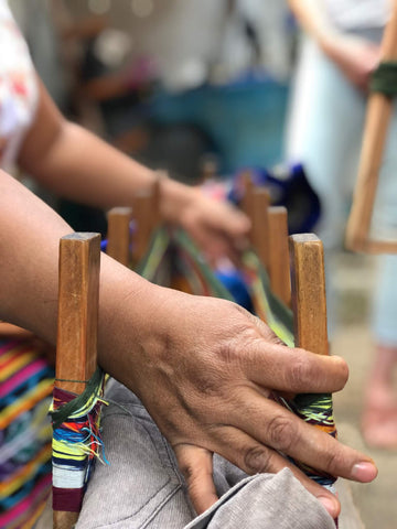 Maya woman's hands weaving fabric