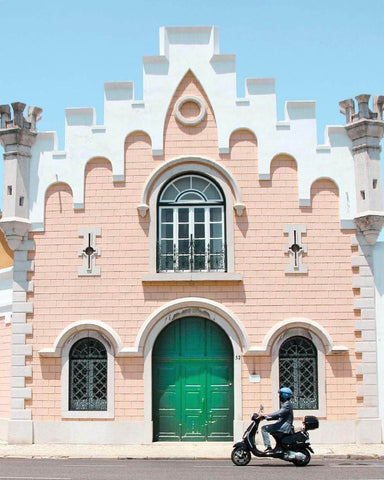 Whimsical pink building with a man on a scooter