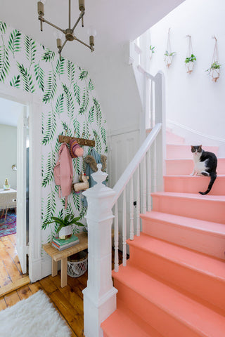 Pink ombre stairs and fern wallpaper in a stairway