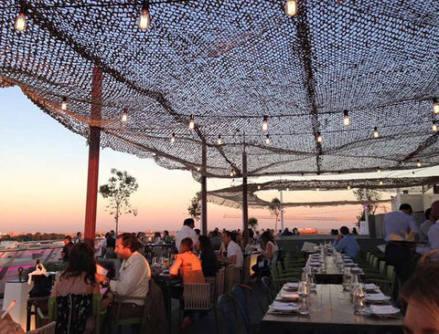 people dining on a rooftop at sunset in Madrid Spain