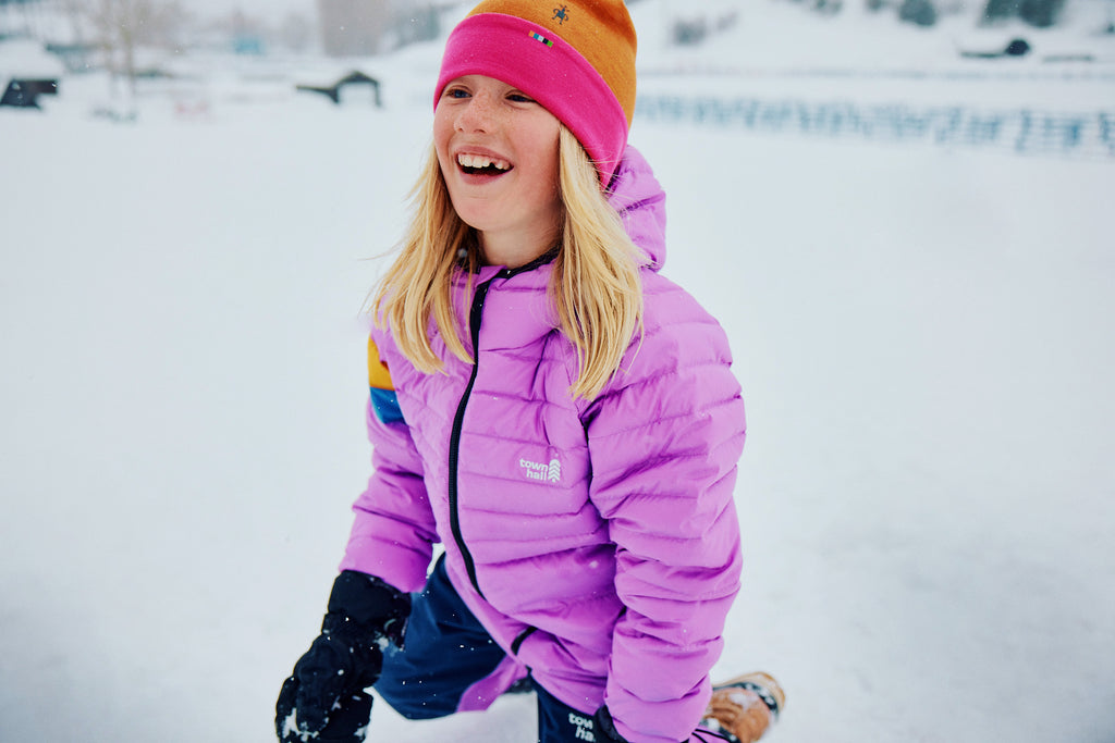 Tiegan wearing a Down Town Puffy while playing in the snow