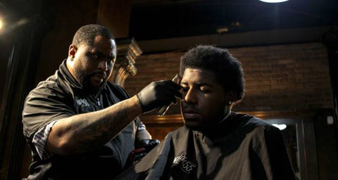 black barber cutting man's hair