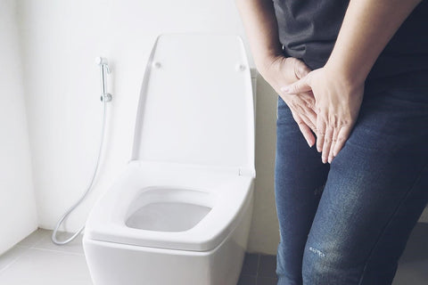 A person suffering from urinary incontinence standing in the toilet - How to soothe vagina after birth postpartum care tips - BeautyFoo Mall Malaysia