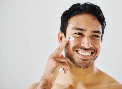 Handsome man applying men skin care products on face - Best Men Skin Care Malaysia Routine - beautyfoomall.com