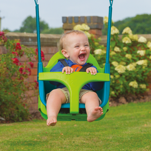 Child swinging in baby swing seat