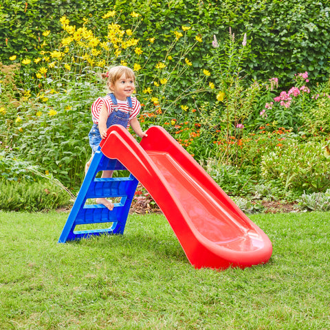 Child playing on plastic garden slide