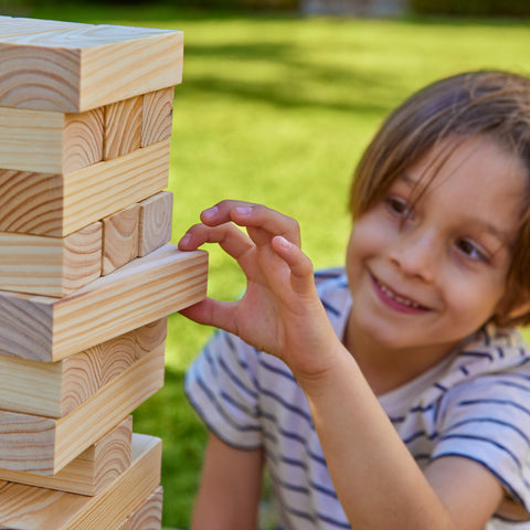 Child playing with wooden tumble tower