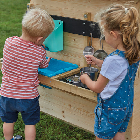 Children playing with playhouse mud kitchen accessory