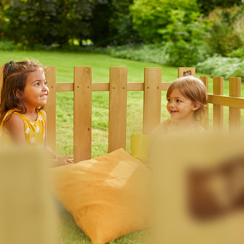 Children playing in garden with wooden fence playhouse accessories