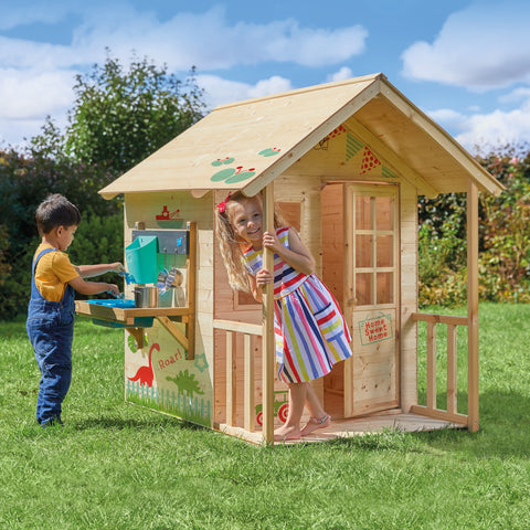 Children playing with a wooden playhouse with mud kitchen