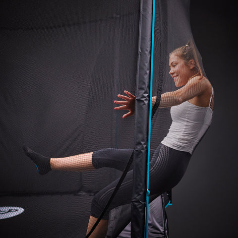 Girl bouncing into trampoline enclosure