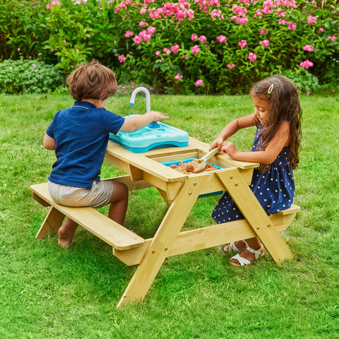 two children at picnic table with sand pit and sink