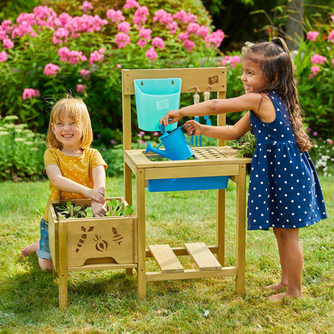 two children tending to vegetables in potting bench