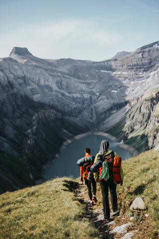Zwei Personen beim Bergwandern mit See im Hintergrund