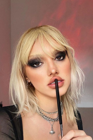 Smudged eyeliner and dark hues epitomized an edgy, rebellious allure inspired by alternative music culture