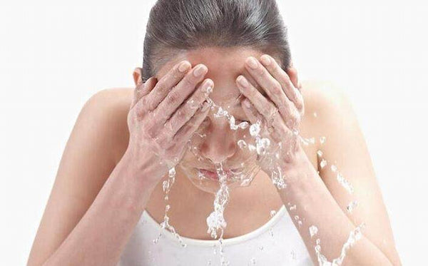 将温水倒在脸上以冲洗掉肥皂