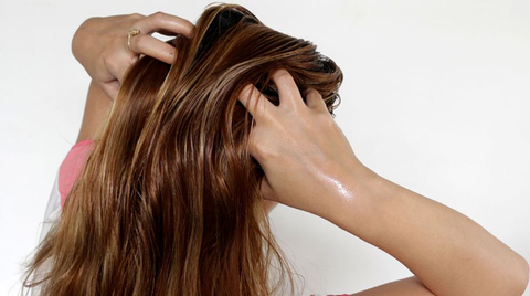 Using fingertips to gently massage the oils on your scalp