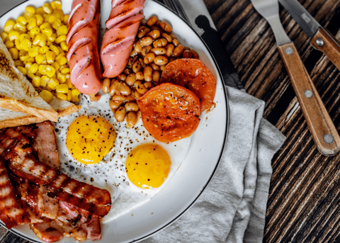 A common Western breakfast may consist of fried eggs, along with bacon or sausage, toast served,...