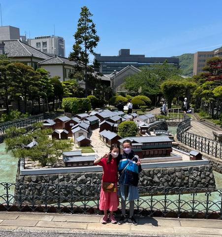 my daughters at Dejima island in Nagasaki, Japan - standing in front of the scale model of Dejima island