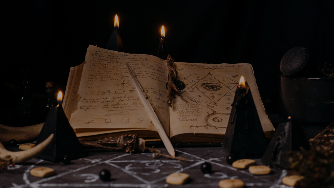 Spellbook with spells written on it and lit candles