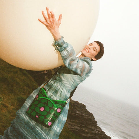 Model wearing Cross Carry Crossbody in green Sixties Stem Emerald pattern