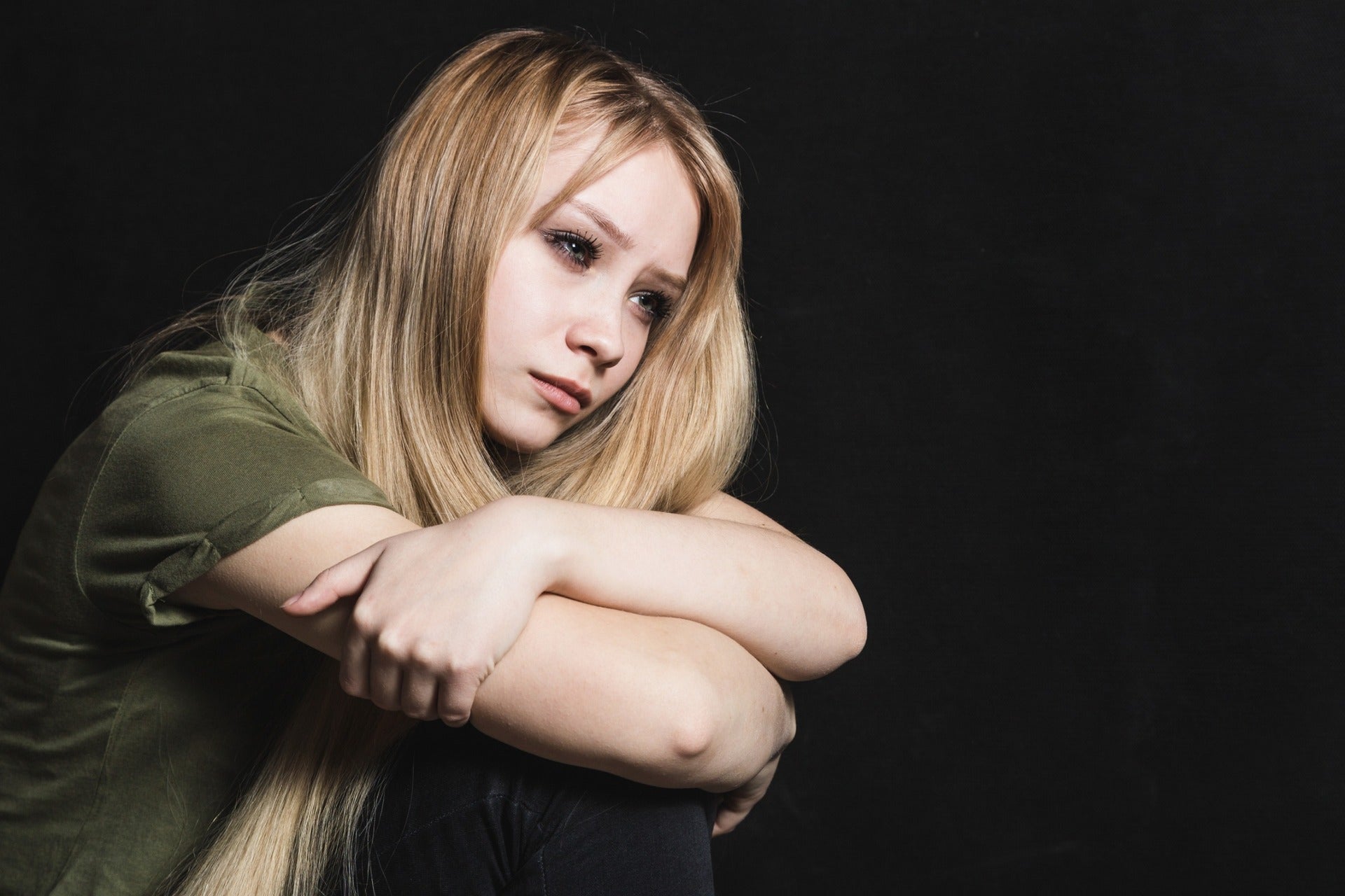 Mujer triste con una pesada mochila emocional