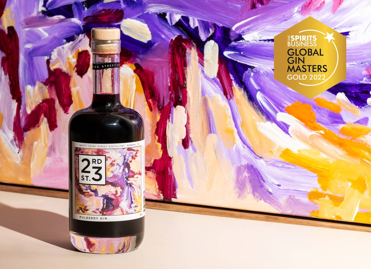 23rd Street Distillery Mulberry Gin in front of painted artwork