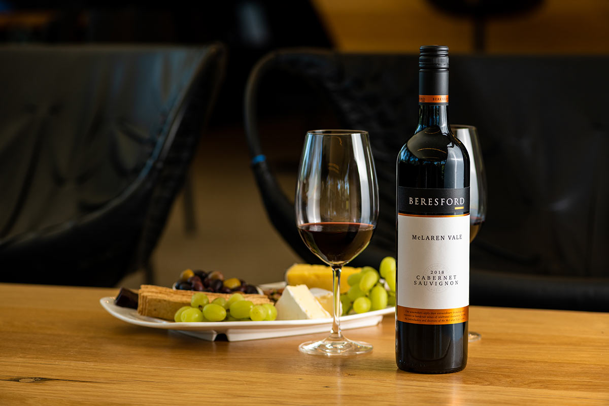Bottle and glass of beresford cabernet sauvignon on table with plate of food