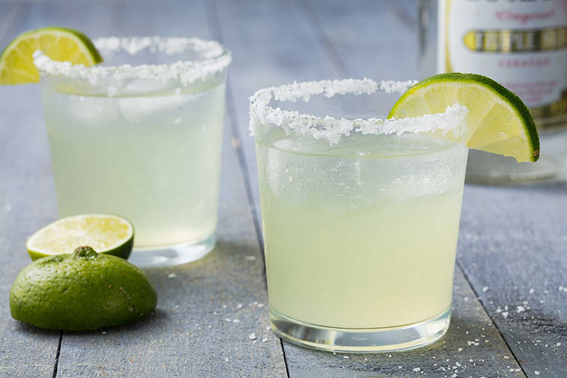 two margarita cocktails in glasses will salted rims