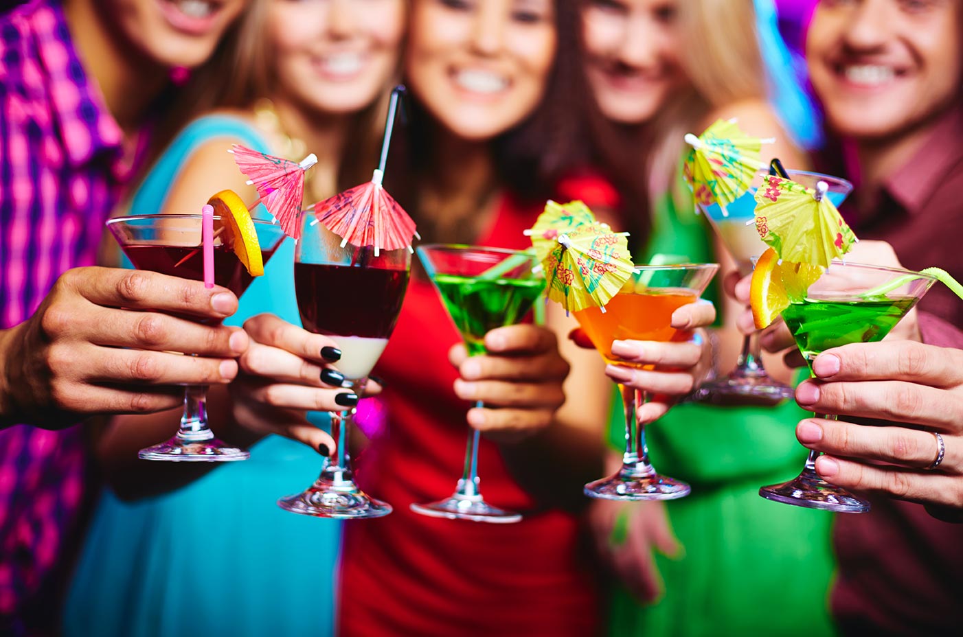 five friends holding colourful cocktails