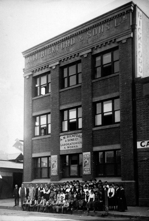Historic black and white Bickfords building with employees sitting in front of the building