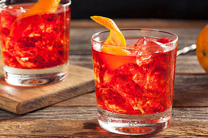 Two Negroni cocktails with an orange peel in the glass