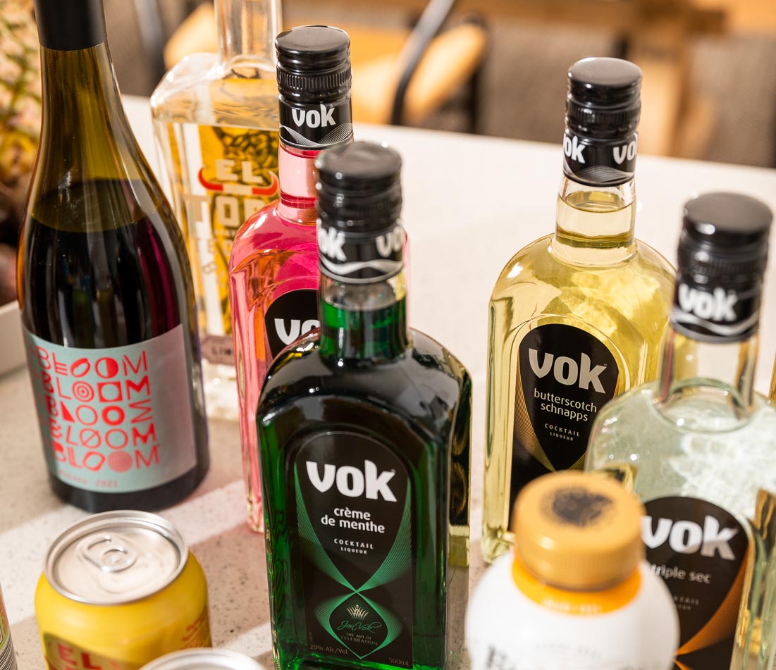 Vok liqueur bottles on a counter with other beverages