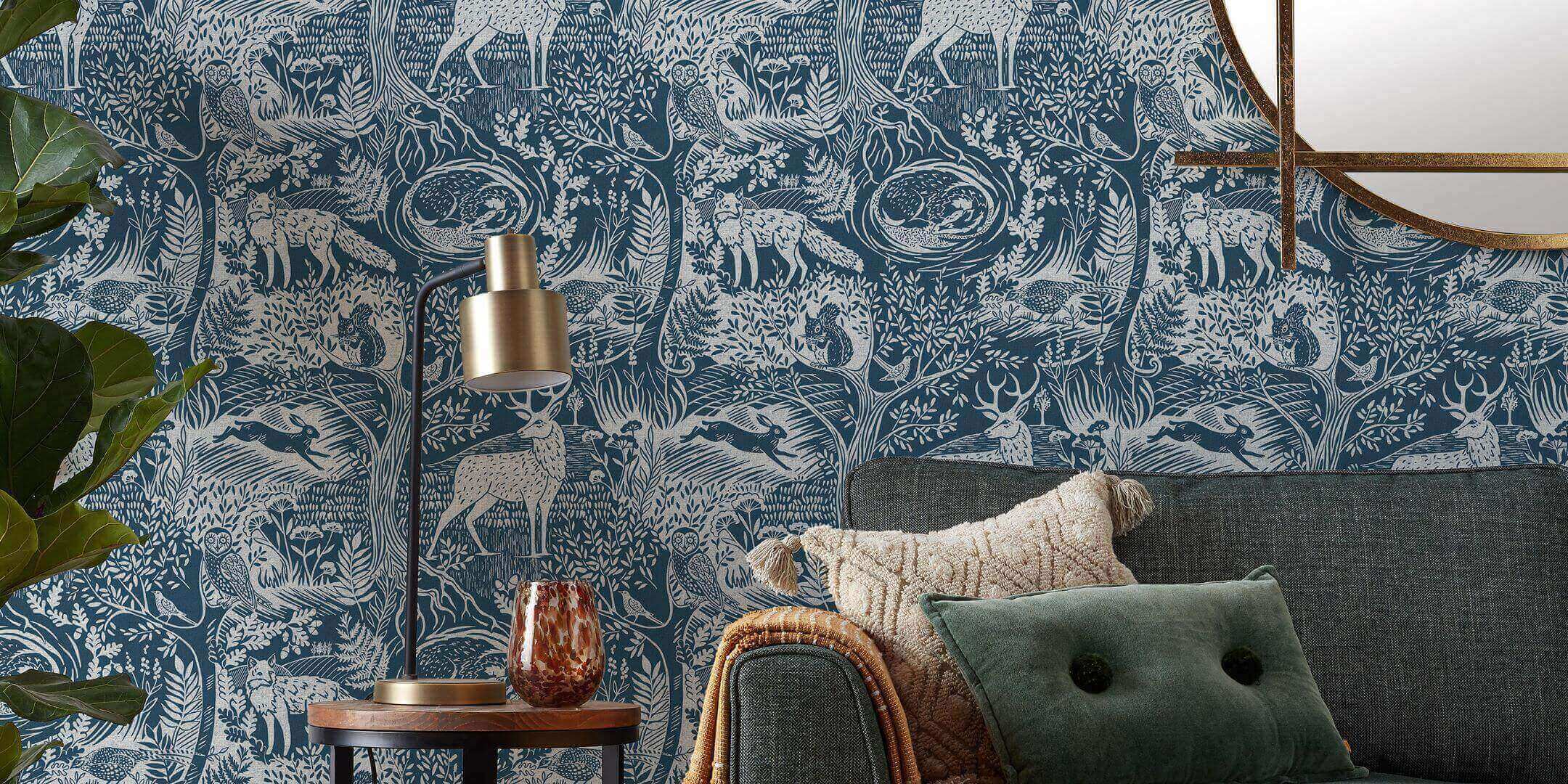 a living room with a woodcut style blue wallpaper featuring a forest and forest animals