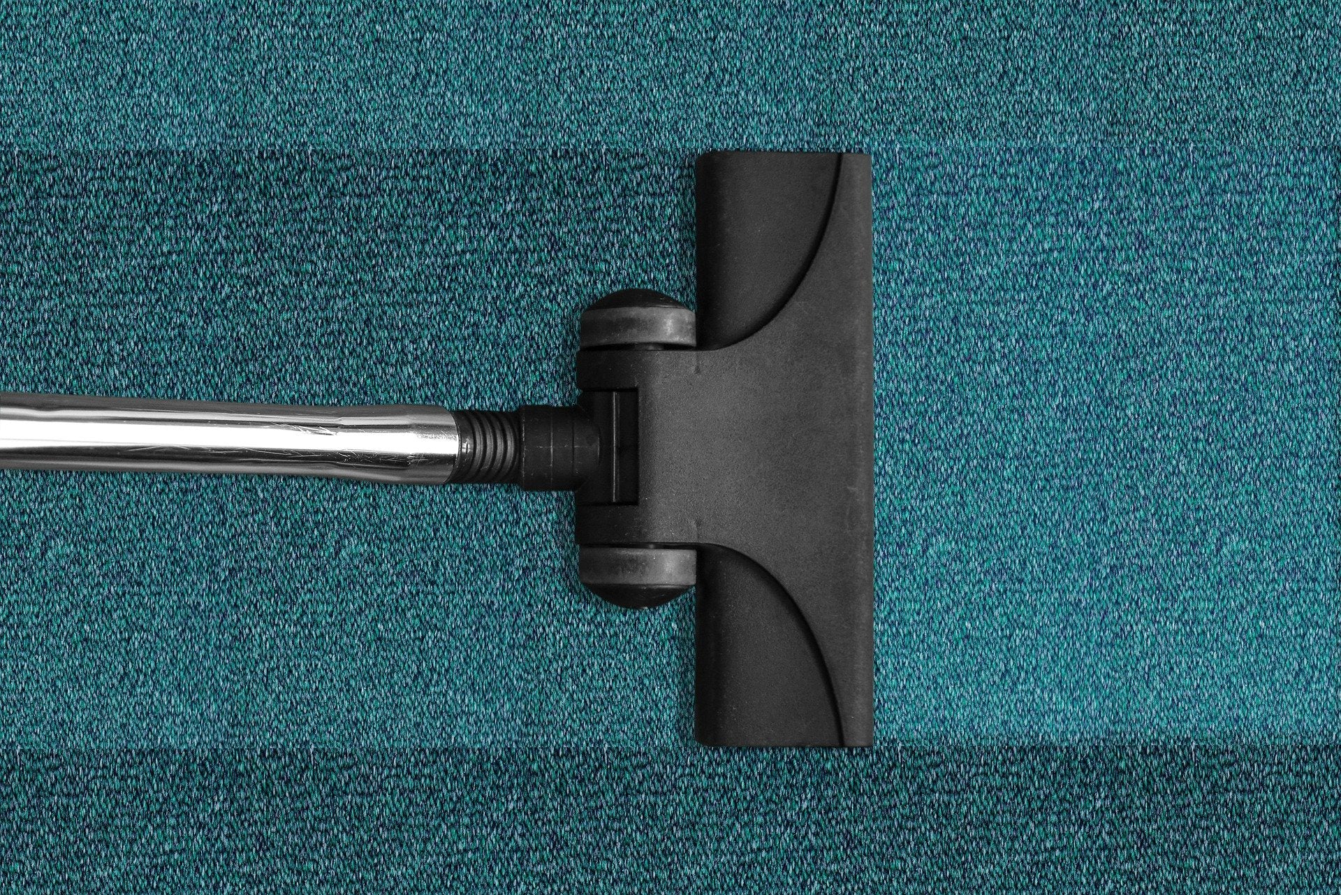 Vacuum cleaning a dirty blue carpet 