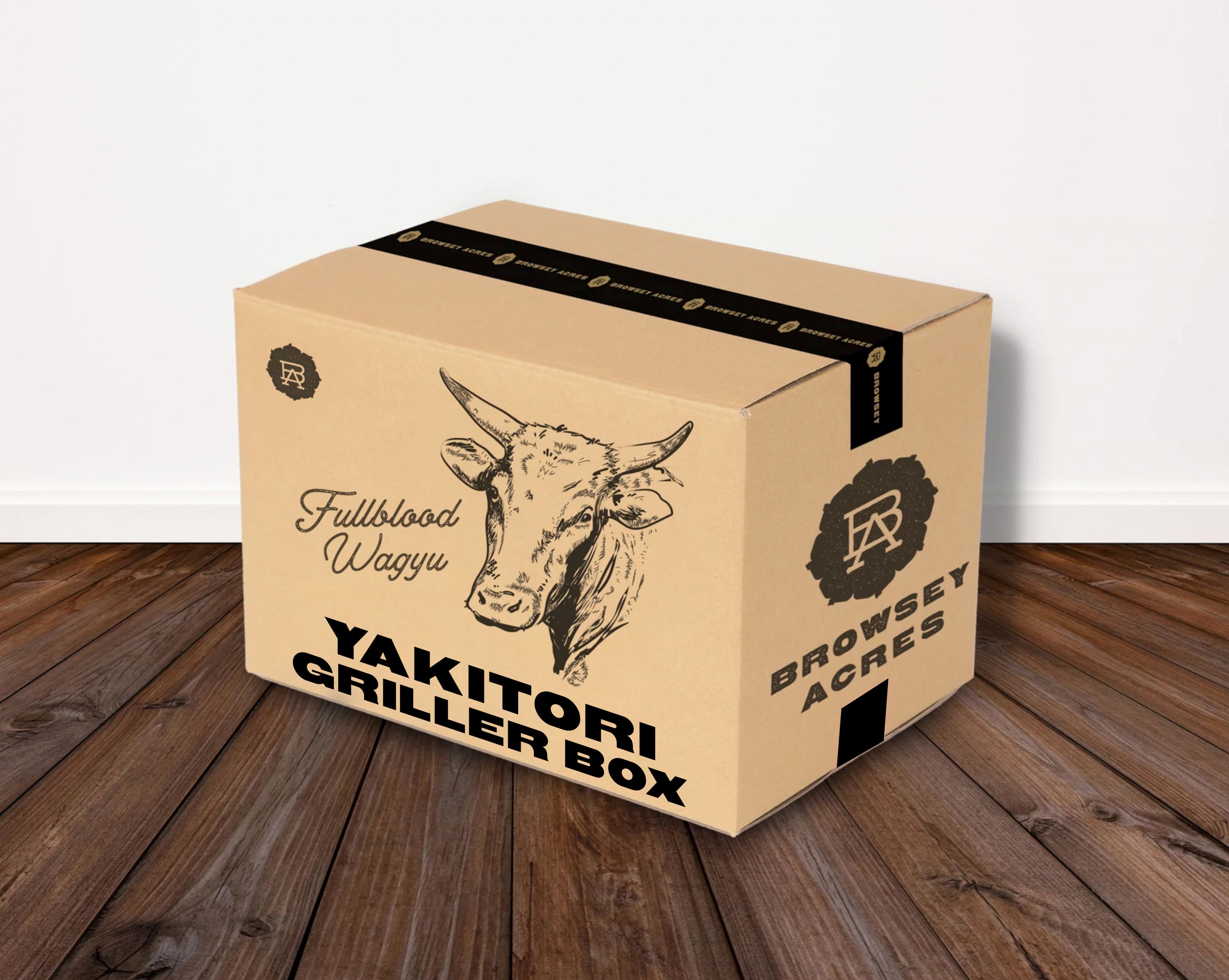 Cardboard box labeled 'Fullblood Wagyu YAKITORI GRILLER BOX' from 'BROWSEY ACRES' on a wooden floor.